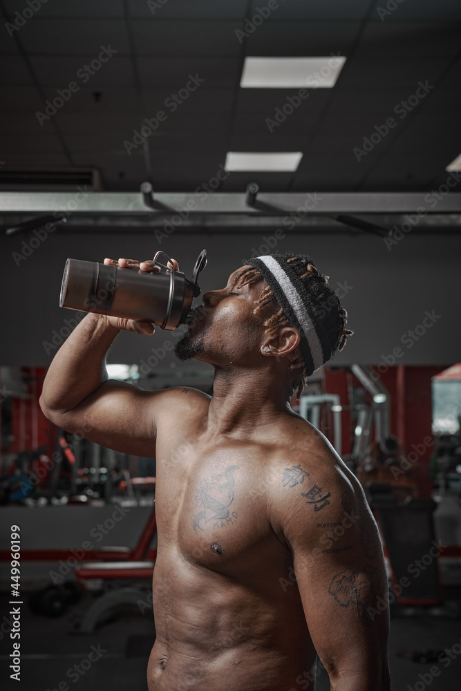 Nutritional supplement. Muscular athletic man drinking protein, energy