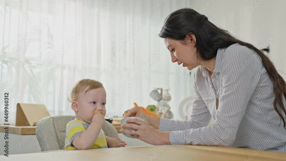 Caucasian beautiful mother take care of baby boy toddler in kitchen. Caucasian beautiful mother take care of baby boy toddler in kitchen.