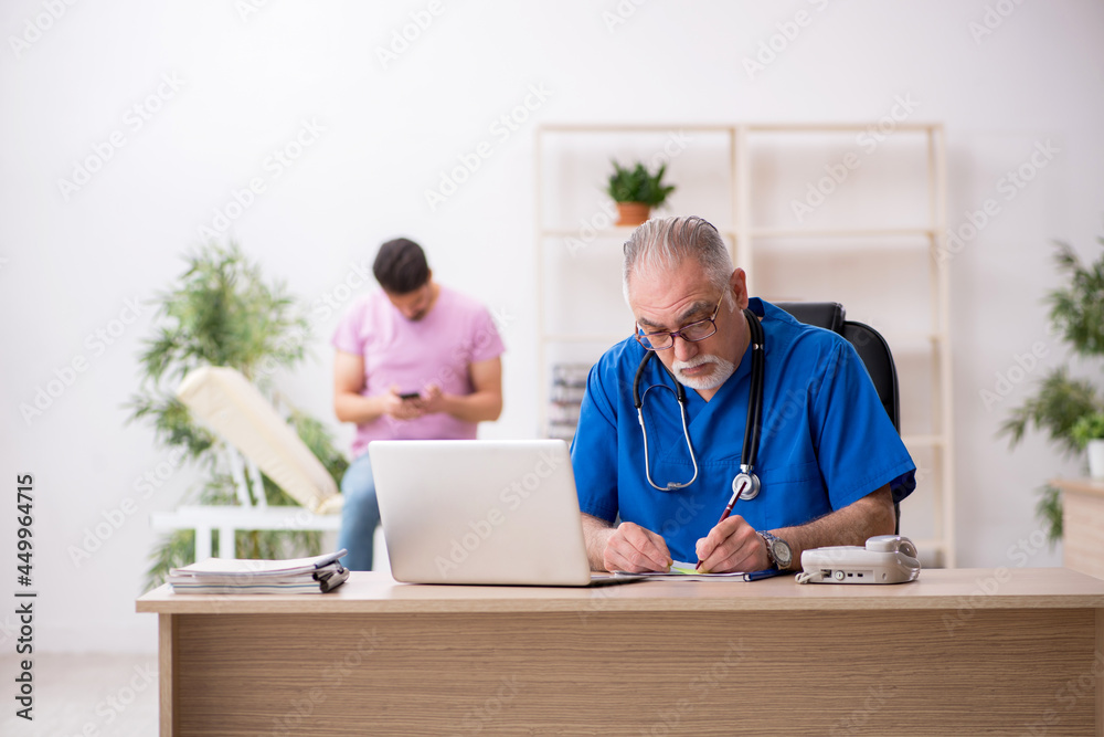 Obraz premium Young male patient visiting old male doctor