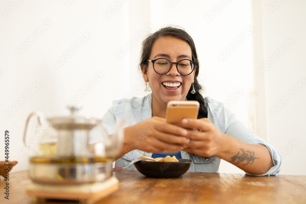 woman texting while having fruit breakfast