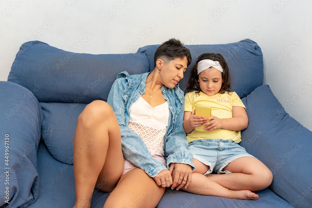 Mother and daughter watching the mobile phone together Mother and daughter watching the mobile phone together