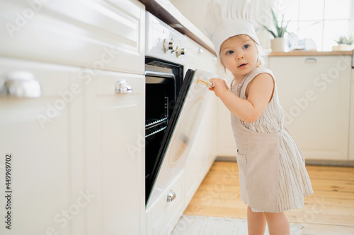 Prepares cookies for breakfast. A little chef is preparing dough in the kitchen. The child plays exciting games at home. A girl of European appearance. © muse studio