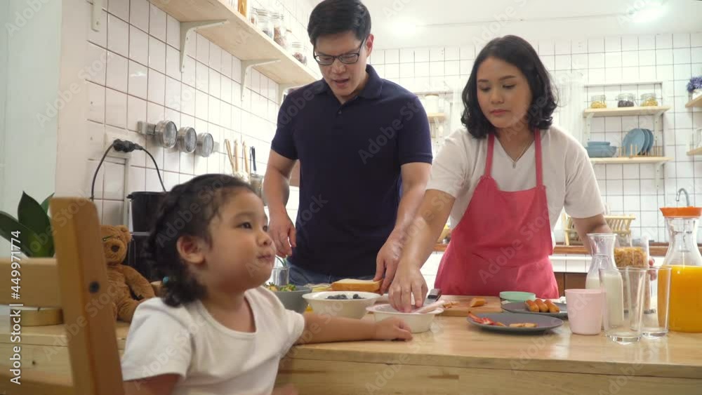 4K Happy Asian family eat breakfast together in kitchen. Asian couple with cute baby daughter preparing food for breakfast meal. Mom and dad with child girl kid enjoy and having fun cooking together. 4K Happy Asian family eat breakfast together in kitchen. Asian couple with cute baby daughter preparing food for breakfast meal. Mom and dad with child girl kid enjoy and having fun cooking together.