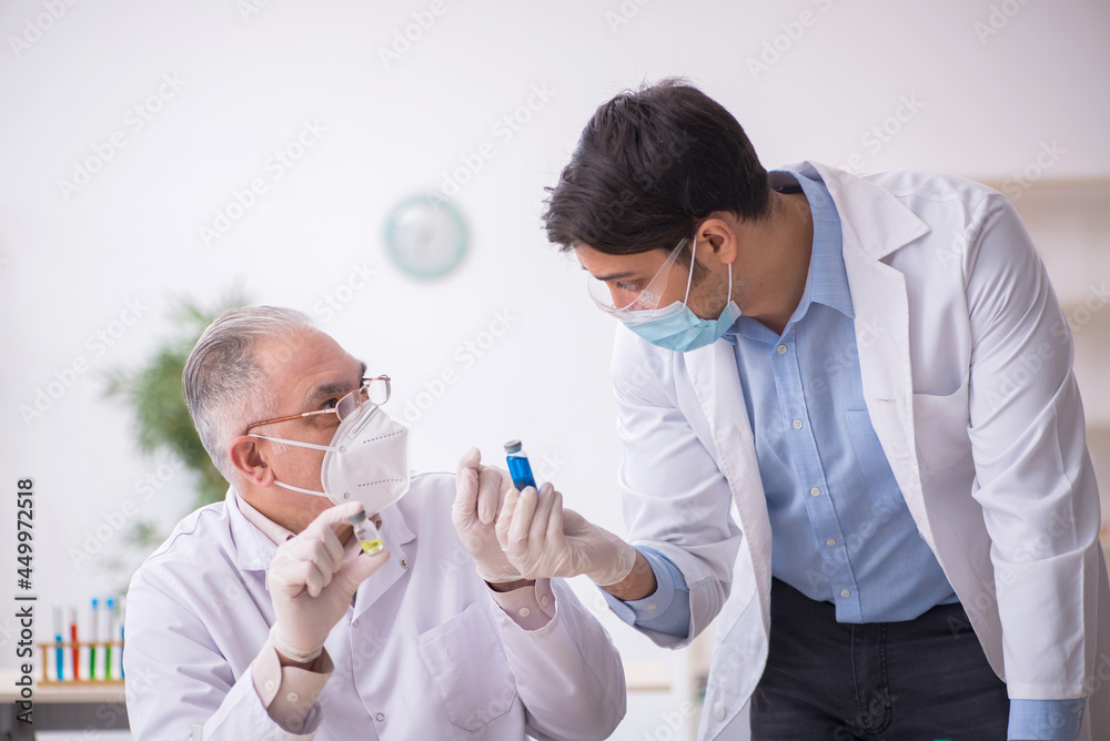 Two male chemists working at the lab during pandemic Two male chemists working at the lab during pandemic