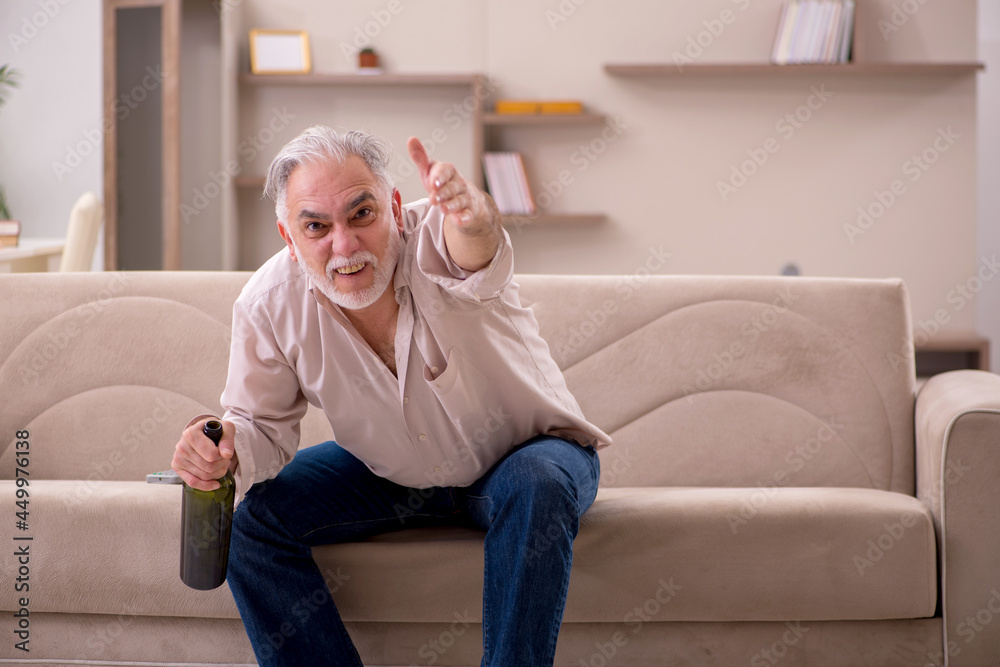 Old man drinking alcohol at home Old man drinking alcohol at home