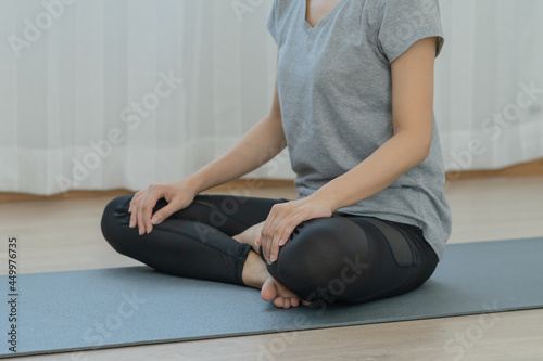 Meditating,asian young woman, girl practice yoga in lotus position, calm pose for meditation, exercise on mat for wellbeing, healthy care in room at home. Workout fitness exercise, sport in sportswear