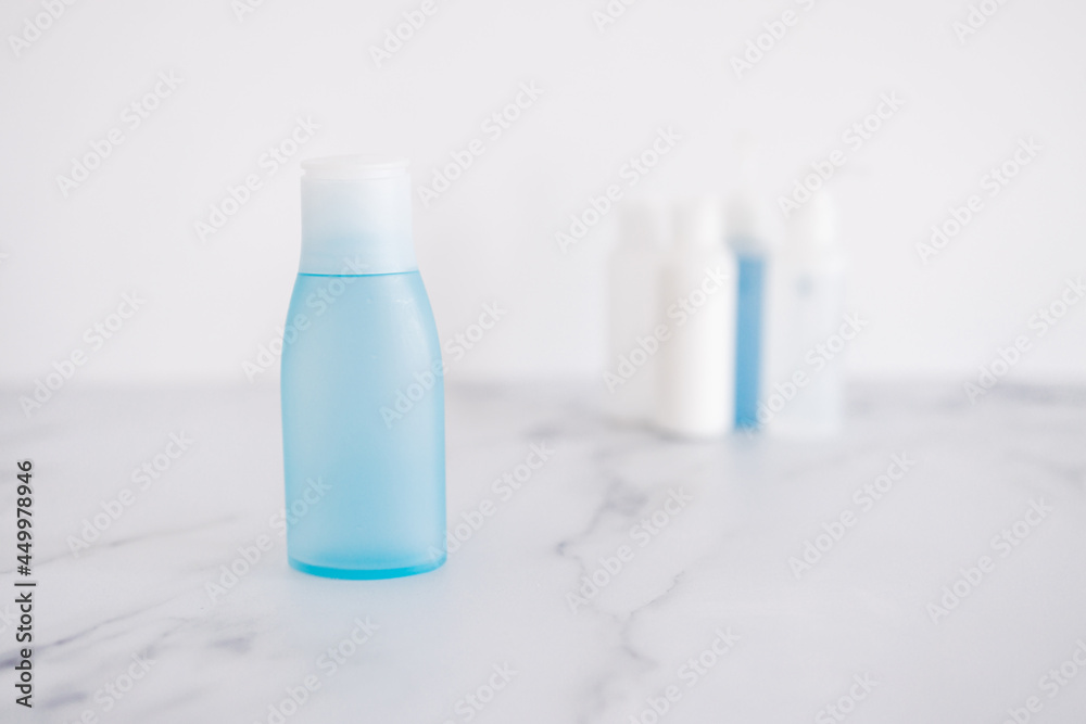 low tox and non-toxic natural beauty products, blue lotion bottle in the foreground standing out from group of other bottles low tox and non-toxic natural beauty products, blue lotion bottle in the foreground standing out from group of other bottles