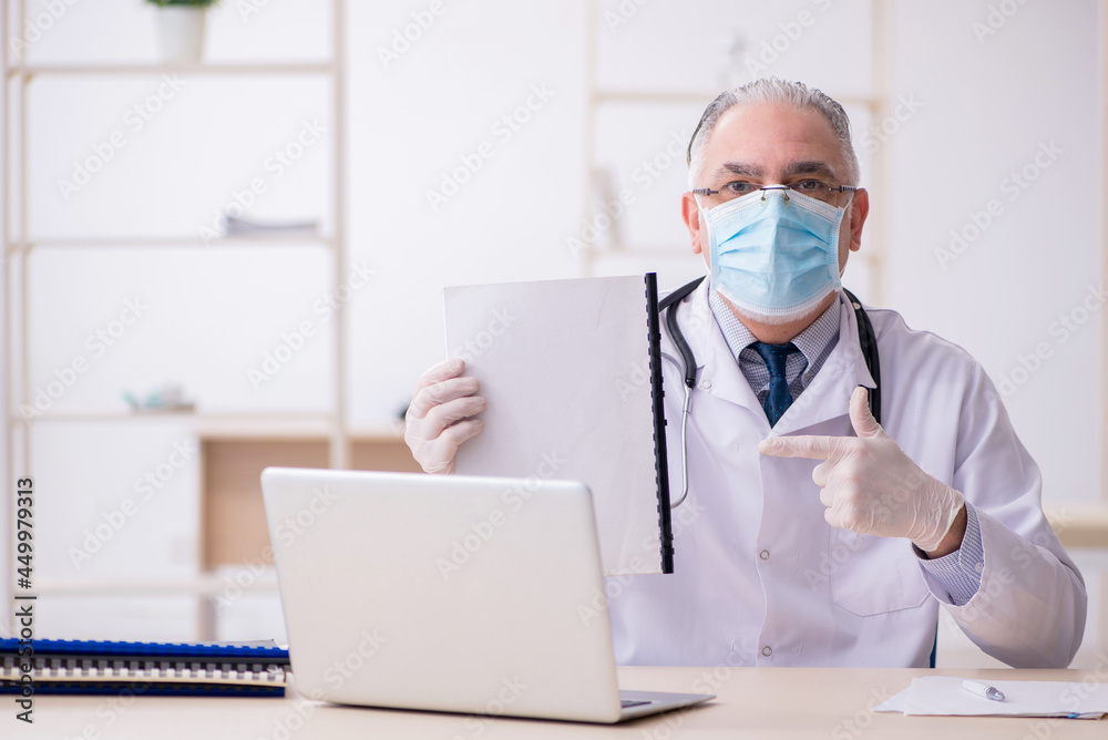 Old male doctor working in the clinic