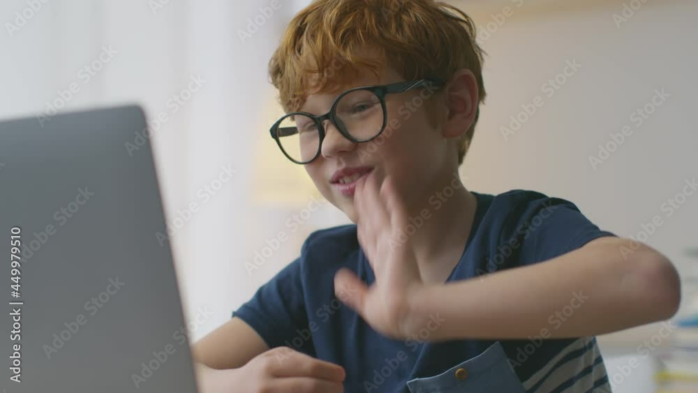 Best online courses for kids. Happy interested little redhead boy wearing eyeglasses video conferencing with teacher Best online courses for kids. Happy interested little redhead boy wearing eyeglasses video conferencing with teacher