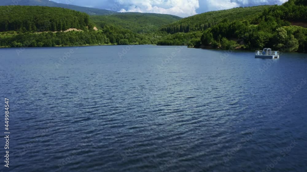 Aerial view of blue lake surrounded by forest. mountains in the background. 4K. lake in the forest. 4. white clouds. Aerial view of blue lake surrounded by forest. mountains in the background. 4K. lake in the forest. 4. white clouds.