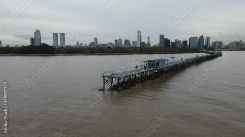 Rotating aerial view of people on long pier over water in the vast endless ocean. photo