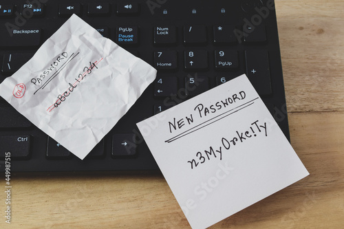 A person's choice of new password containing alphanumeric characters laid on computer keyboard on office desk. Long password for online security. Conceptual, selective focus on the text.