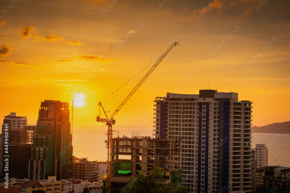 Business Engineering and Real Estate Development, Construction Contractor Worker Working Civil Work at Construction Site. Skyscraper Building Apartment During Progress Construction Project at Sunset.