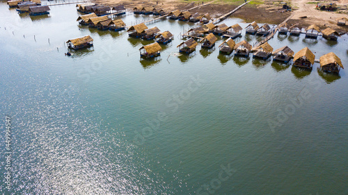 Scenery bamboo raft cottages on the lake with sunshine reflect on water. Summer vacation destinations. Aerial view.