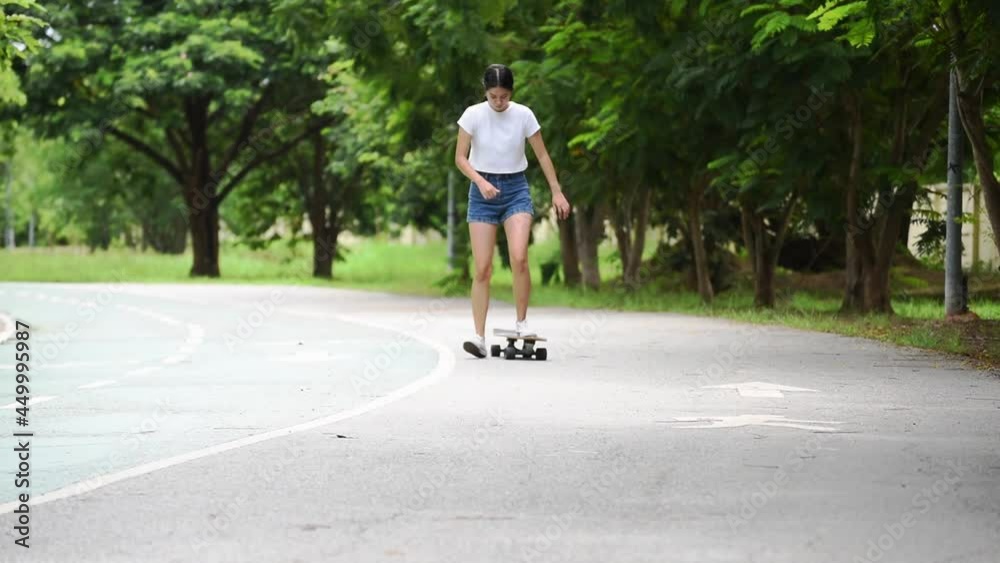 girl in denim shorts, posing in summer with colorful skateboard longboard. lifestyle concept girl in denim shorts, posing in summer with colorful skateboard longboard. lifestyle concept