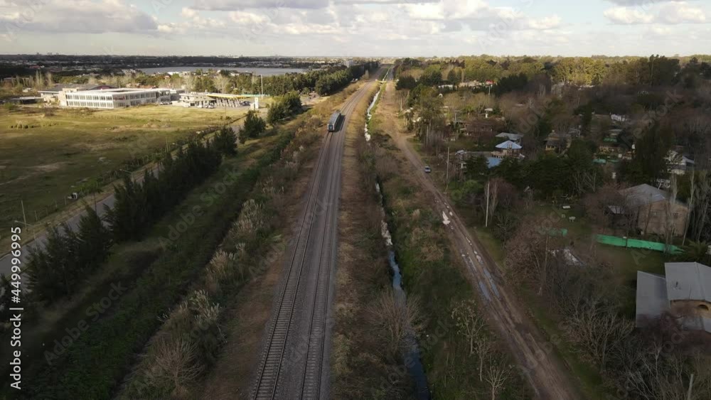 Aerial follow shot of train driving in rural landscape during sunny day, Buenos Aires, Argentina Aerial follow shot of train driving in rural landscape during sunny day, Buenos Aires, Argentina