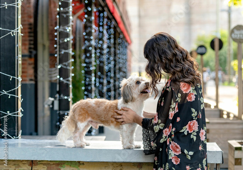 a woman posing with her small mixed breed dog at dumbo, brooklyn 