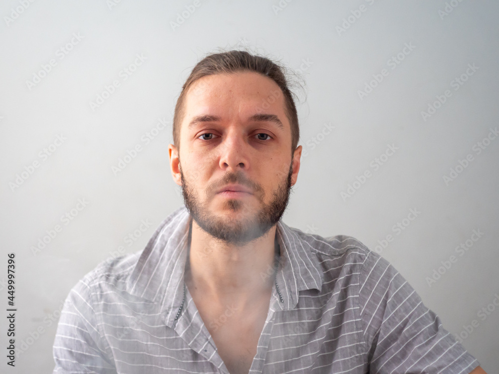 Caucasian Male in Grey Shirt Smoking Legal Cannabis Joint Blows Down Happily