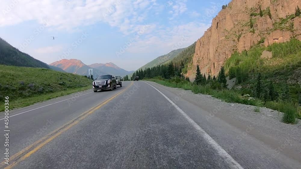 POV while driving on Million Dollar Highway in Uncompahgre River Valley with dramatic views of San Juan Mountains near Ouray Colorado; concept of open road adventure POV while driving on Million Dollar Highway in Uncompahgre River Valley with dramatic views of San Juan Mountains near Ouray Colorado; concept of open road adventure