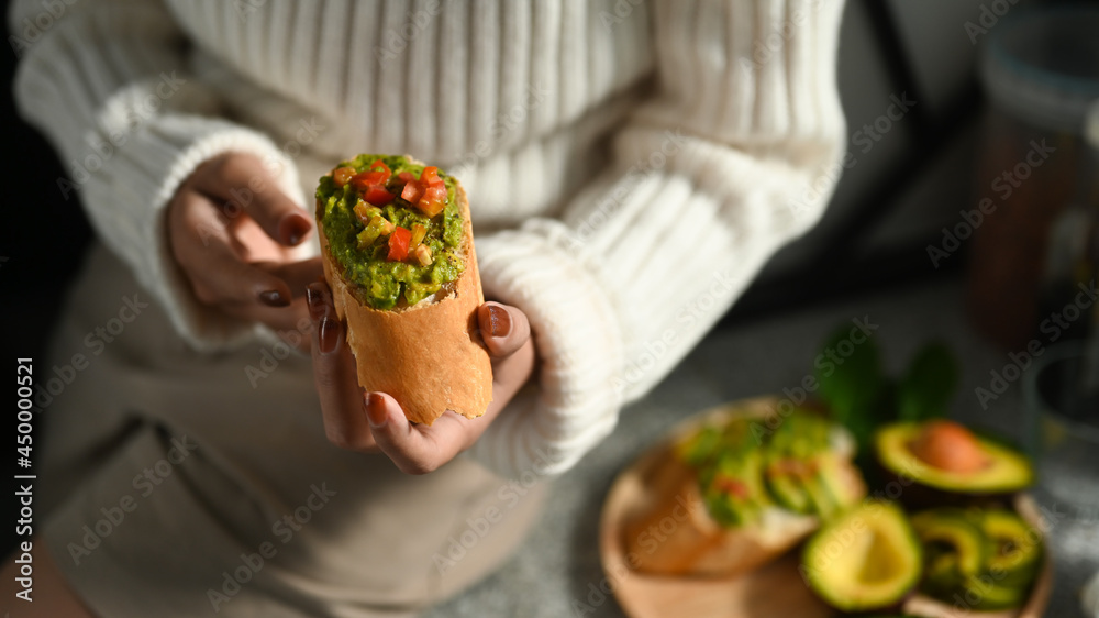 ัYoung woman holding healthy avocado toasts for breakfast. ัYoung woman holding healthy avocado toasts for breakfast.