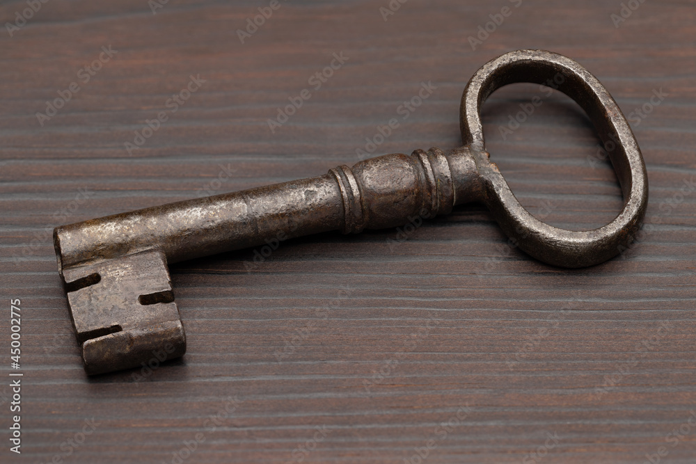 Old door, metal key on brown wood background, studio shot. Old door, metal key on brown wood background, studio shot.