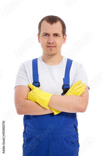 portrait of male cleaner in blue uniform and yellow gloves posing isolated on white