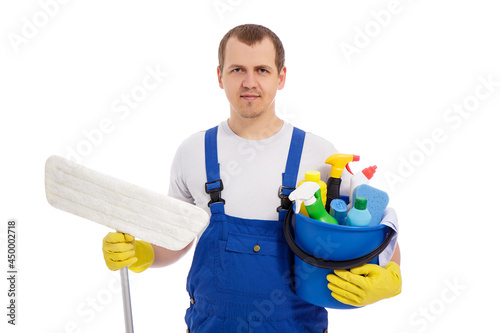 portrait of male cleaner in blue uniform and yellow gloves holding mop and bucket with cleaning equipment isolated on white background