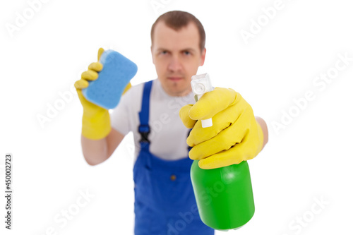 male cleaner in blue uniform cleaning window with wipe and detergent isolated on white background, focus on the bottle of detergent