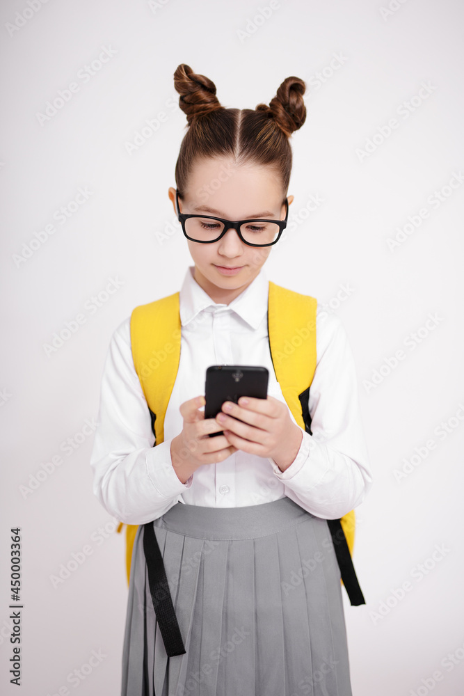 portrait of cute girl in school uniform and eyeglasses using smart phone over white background portrait of cute girl in school uniform and eyeglasses using smart phone over white background