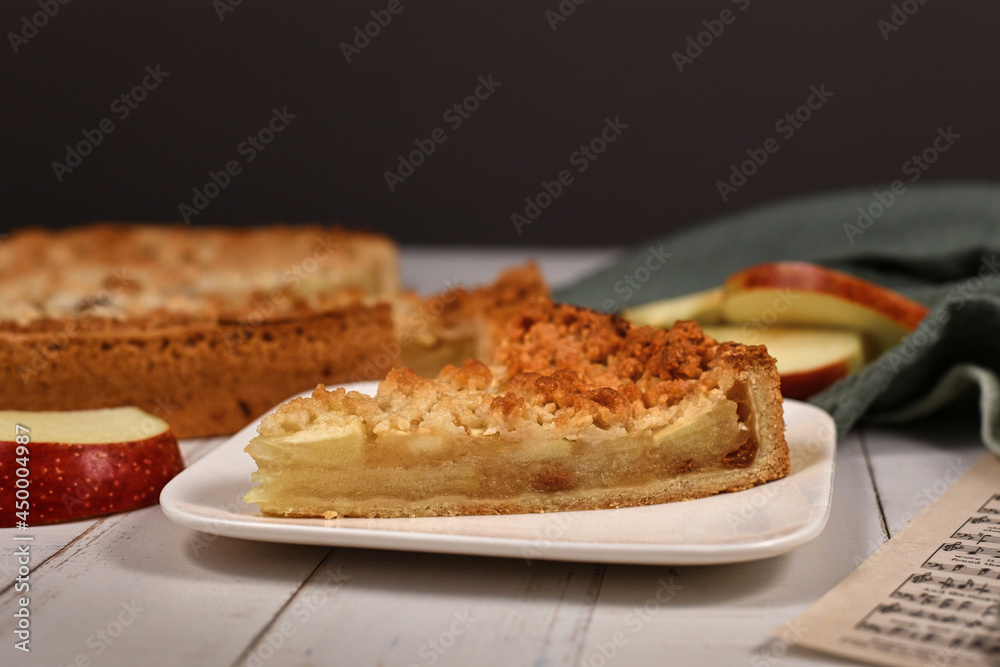 Slice of traditional European apple pie with topping crumbles called Streusel on plate Slice of traditional European apple pie with topping crumbles called Streusel on plate