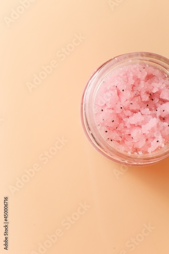 Body scrub of sea salt with lemon, rosemary and olive oil in glass jar on stone table, homemade cosmetic for Spa care