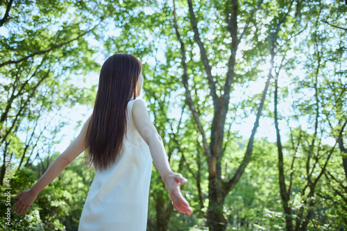 森の中でリラックスする若い日本人女性