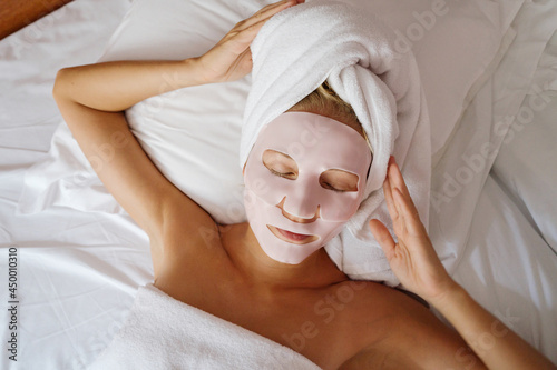 Woman laying in bed wearing a face mask