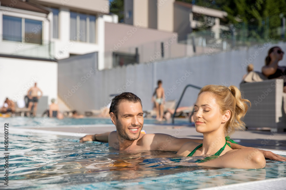 Attractive couple relaxing in the hotel swimming pool