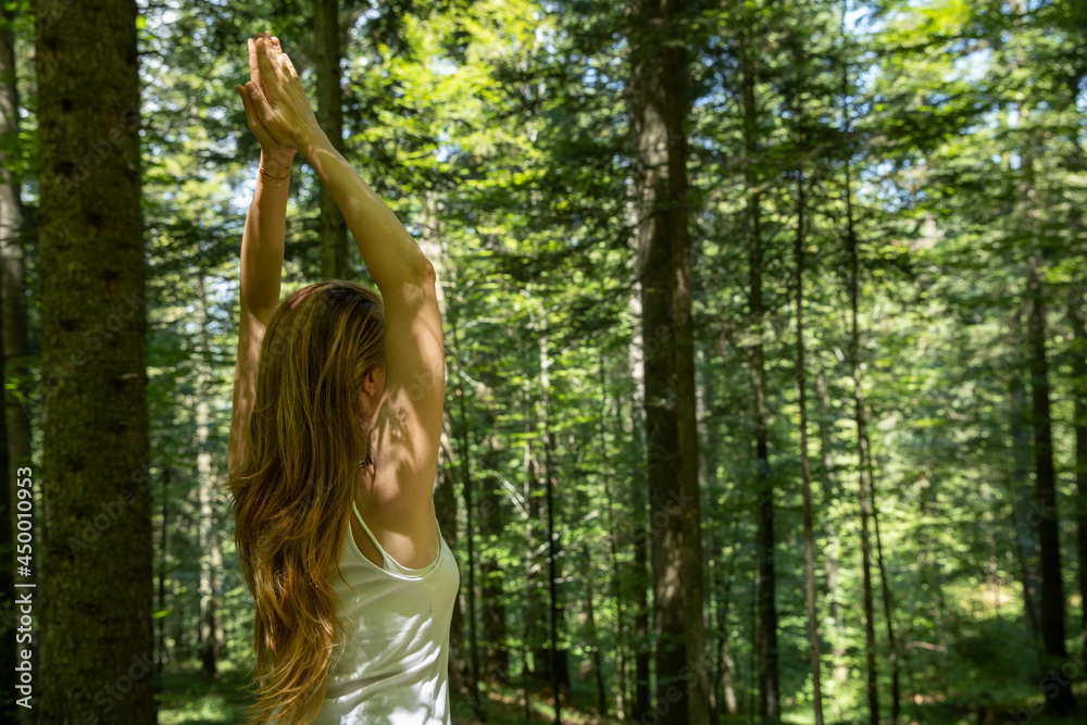 Woman doing yoga alone in the forest Woman doing yoga alone in the forest