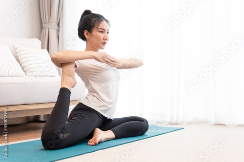 Productive activity concept a girl with a bun wearing the white t-shirt doing the difficult pilates move