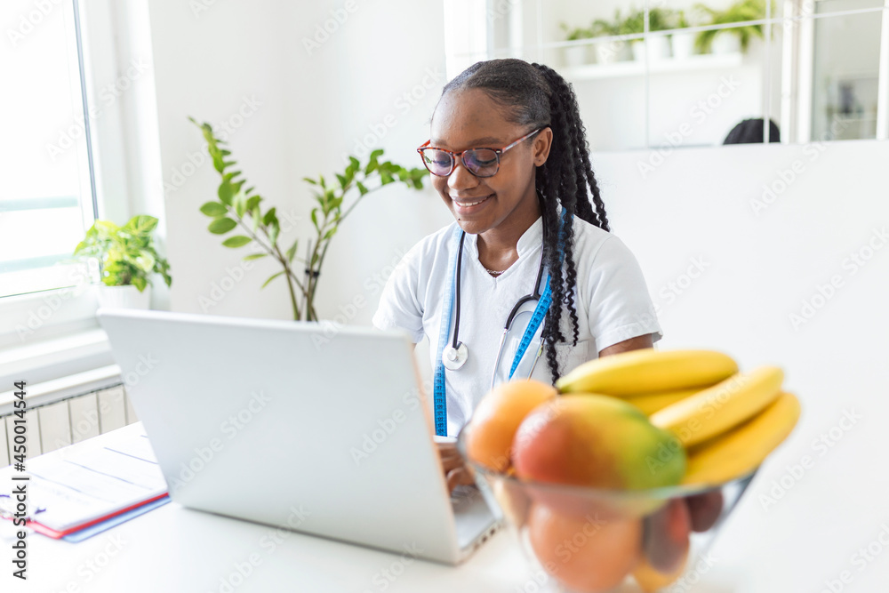 Smiling nutritionist in her office, she is showing healthy vegetables and fruits, healthcare and diet concept. Female nutritionist with fruits working at her desk. Smiling nutritionist in her office, she is showing healthy vegetables and fruits, healthcare and diet concept. Female nutritionist with fruits working at her desk.