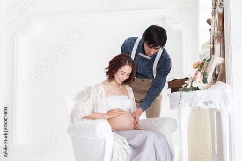 妊娠した妻のお腹に手を添える夫