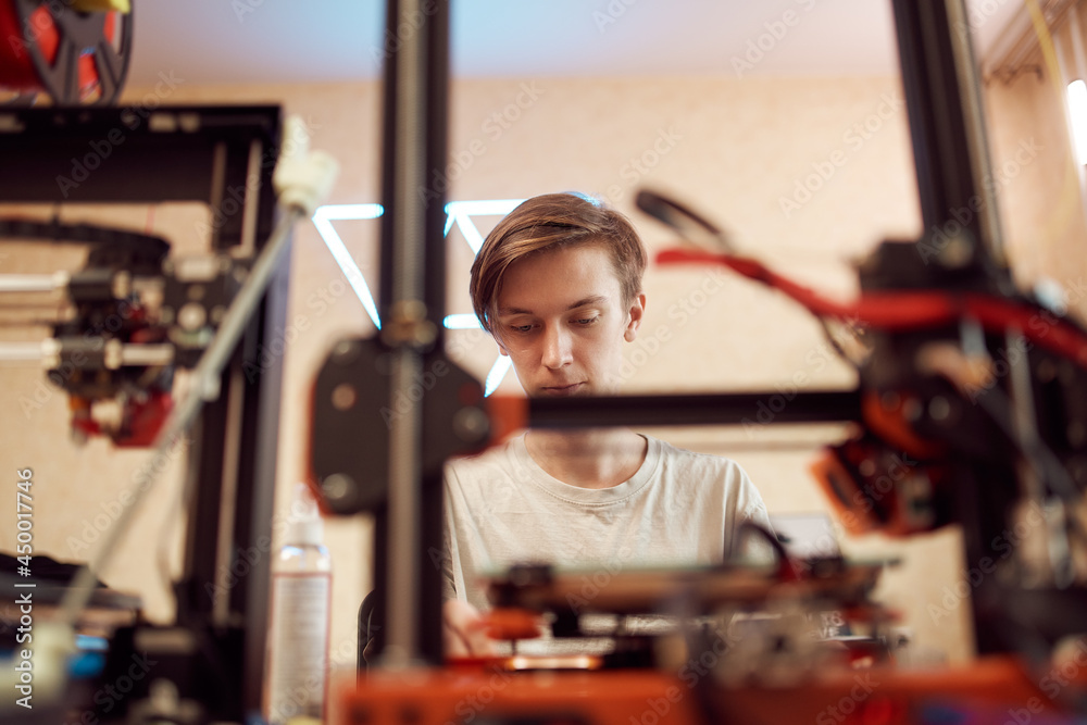 Young man set up 3d printer Young man set up 3d printer