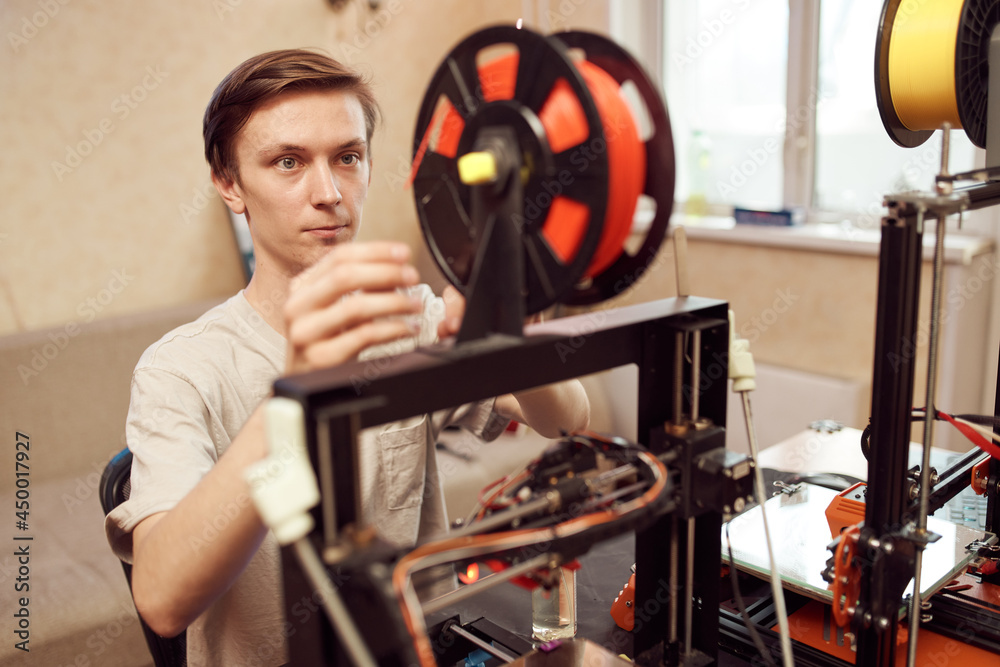 Fototapeta premium Young man set up 3d printer