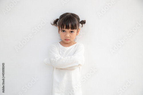 Angry little girl over white background, sign and gesture concept