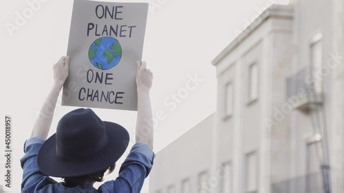 Demonstrator on the city protesting against climate change and pollution - Global warming and environment concept - Focus on banner photo