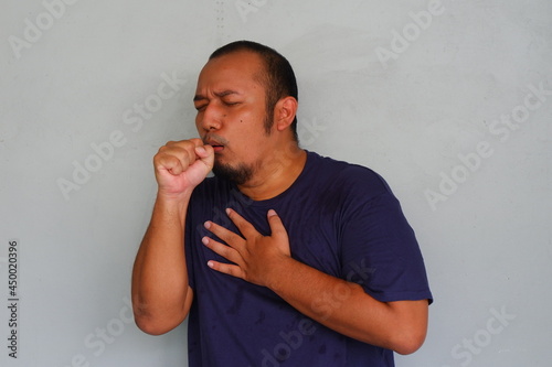 Young asian man feeling sick and coughing