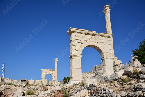 ruins of ancient town Sagalassos with gates and stones on blue sky background