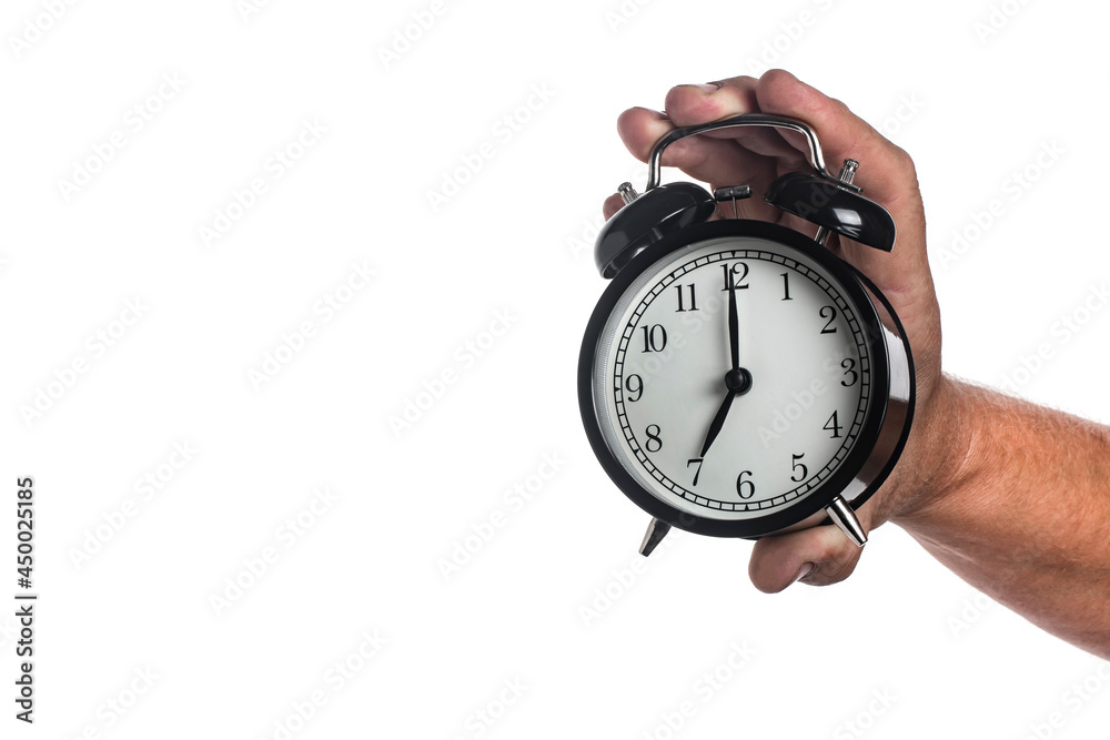 Black alarm clock in a man's hand isolated on white background. Black alarm clock in a man's hand isolated on white background.