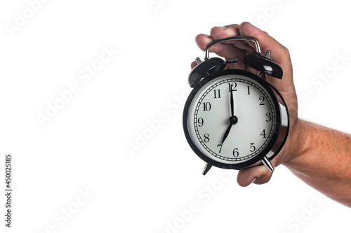 Black alarm clock in a man's hand isolated on white background.