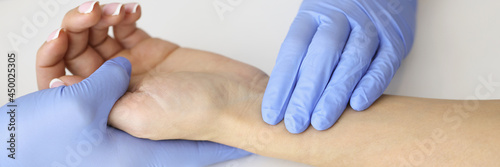 Fotografi Doctor measuring pulse on patient forearm near empty syringe and medication clos