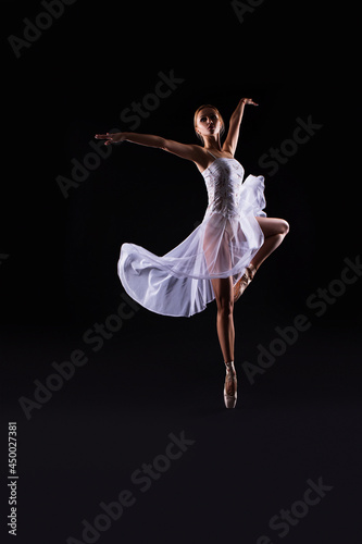 beautiful Ballerina dancer in studio on a dark background