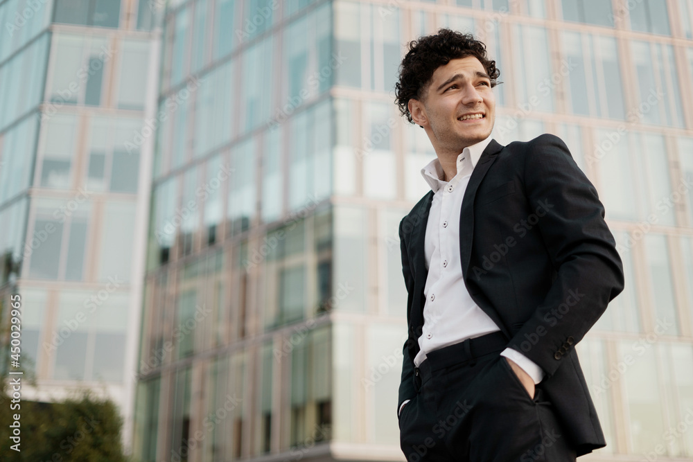 A businesslike young entrepreneur in a suit near a new office in the city center. A businesslike young entrepreneur in a suit near a new office in the city center.