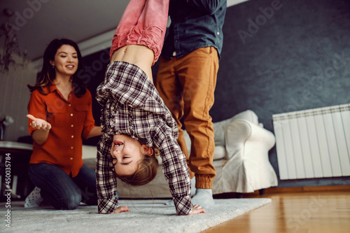 Photography Father playing with his daughter and teaching her how to make headstand